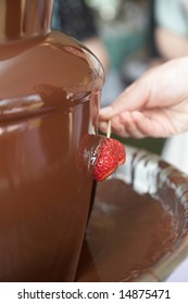 Chocolate Fondue Fountain With Strawberry Being Dipped