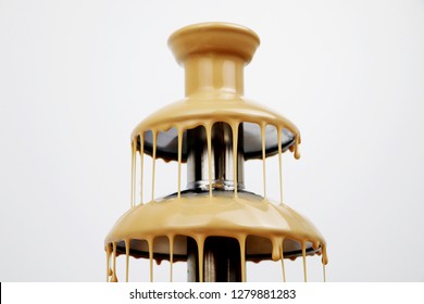 Chocolate Fountain Of Condensed Milk, Isolated On White Background. Delicious Fondue Dessert