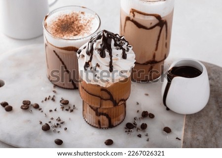 Chocolate frappe in a variety of glasses with chocolate syrup, fancy coffee drinks