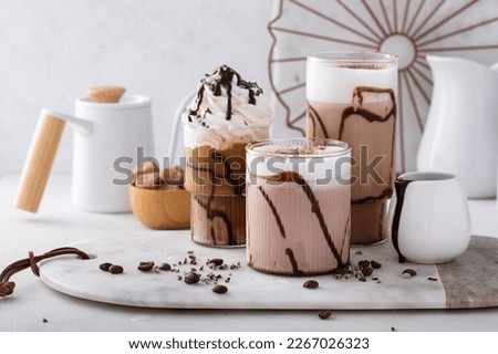 Chocolate frappe in a variety of glasses with chocolate syrup, fancy coffee drinks
