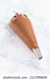 Chocolate Ganache Frosting In A Piping Bag With A Metal Tip.