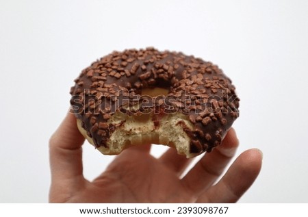 Chocolate glazed donut with springles bite snack meal food served on white background
