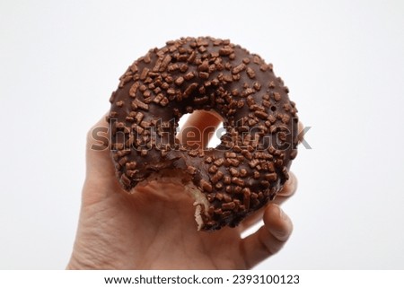 Chocolate glazed donut with springles bite snack meal food served on white background