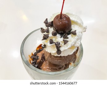 Chocolate ice cream with chocolate coated cherry and whipped cream - Powered by Shutterstock