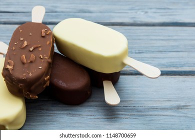 Chocolate ice cream lollies on a wooden background.