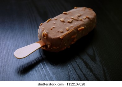 Chocolate Ice Lolly With Almonds On The Wooden Vintage Table. Ice Cream Bar,summer Hot Day. Cold Yummy Ice Cream .Ice Cream Concept.