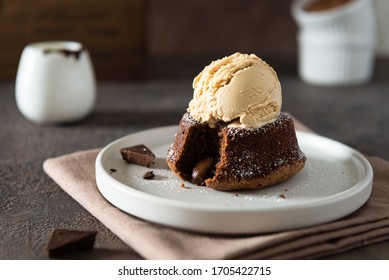 Chocolate lava cake with ice cream served on plate on dark background. Confectionery, cafe, restaurant menu, recipe, cookbook. Side view - Powered by Shutterstock