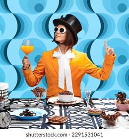 Chocolate lover. Stylish young woman in top hat, sunglasss and orange jaket drinking juice and eating chocolate sweets. Blue pattern background. Concept of pop art, creativity, food, inspiration