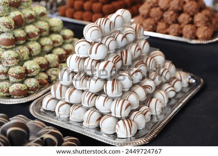 Chocolate marzipan candies filled various flavors. Sweetness balls build as a pyramid for sle in a pastry shop
