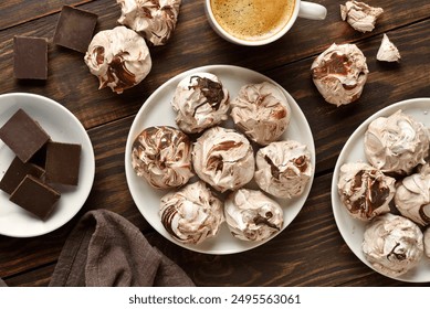 Chocolate meringue cookies and cup of coffee on wooden table. Top view, flat lay - Powered by Shutterstock