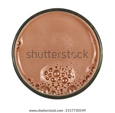 Chocolate milk puddle in glass isolated on white, top view