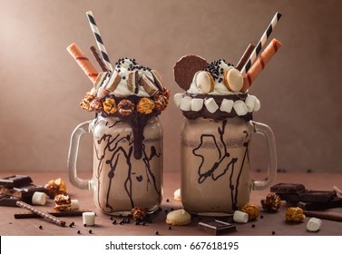 Chocolate  milkshake with ice cream and with whipped cream, marshmallow, sweet popcorn, cookies, waffles, served in glass mason jar. "Freak or crazy" sweet shake.