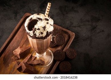 Chocolate milkshake with pieces of chocolate chip cookies.