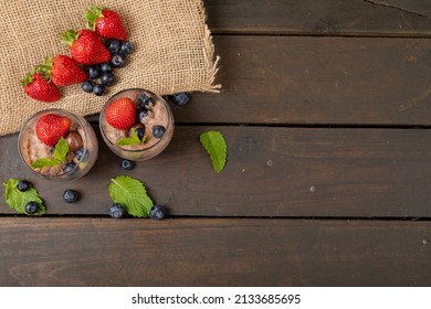 Chocolate Mousse With Berry Fruits, Coated Nuts And Mint Leaves Served In Glasses By Burlap On Table. Unaltered, Copy Space, Dessert, Sweet Food, Herb, Berry Fruit, Burlap And Chocolate Indulgence.