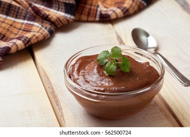 Chocolate Mousse And Mint In A Glass Bowl On A Wooden Background