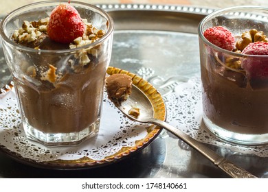 Chocolate Mousse In A Transparent Cup Decorated With Walnuts And Frozen Strawberries