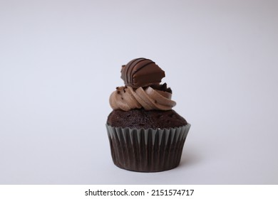 Chocolate muffin with mousse and kinder on top photo from an angle and from a side with white background