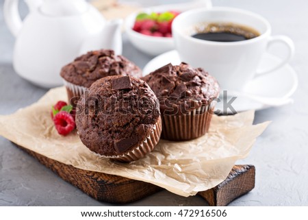 Chocolate muffins with a cup of coffee and fresh berries on the table
