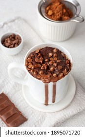 Chocolate Mug Cake In White Cup With Chocolate Drops And Coca Powder