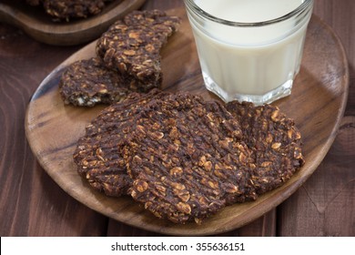 chocolate oatmeal cookies and a glass of milk, top view, horizontal