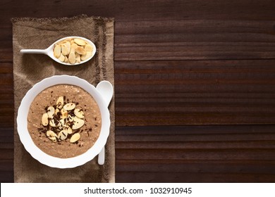 Chocolate Oatmeal Or Oat Porridge With Toasted Almond Slices And Grated Chocolate On Top Served In Small Bowl, Photographed Overhead With Natural Light (Selective Focus, Focus On The Porridge)