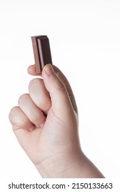 Chocolate ounce held by a hand of an unrecognizable young girl on white background