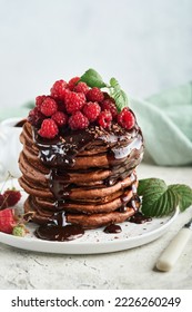 Chocolate Pancakes. Pancakes with fresh raspberry with chocolate glaze or toppings in gray bowl on light gray table background. Homemade classic american pancakes. Page for magazine concept. - Shutterstock ID 2226260249