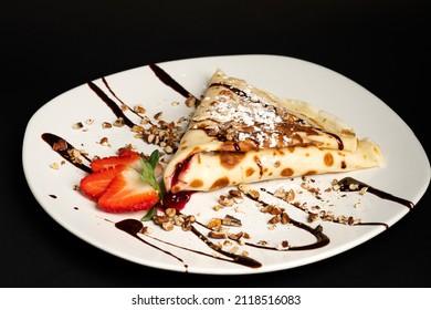 Chocolate pancakes placed on a white plate with ice sugar and chocolate coating - Powered by Shutterstock