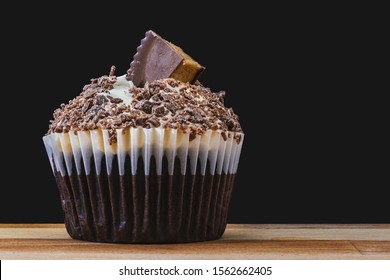 Chocolate Peanut Butter Cup Cake Decorated With Buttercream, Chocolate And Sweet Topping On Wooden Table With Black Background