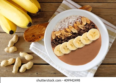 Chocolate Peanut-butter Banana, Smoothie Bowl Overhead Scene On Rustic Wood Background