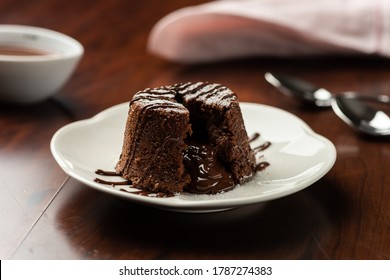 chocolate petit gateau and cocoa with hot melted inside . background and recipe ingredients on wooden table