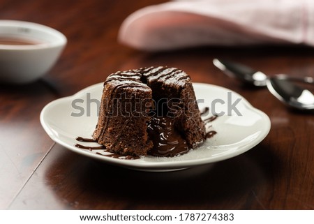 chocolate petit gateau and cocoa with hot melted inside . background and recipe ingredients on wooden table
