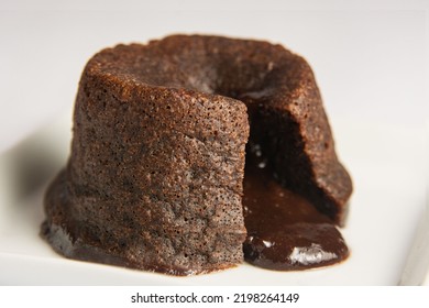 chocolate petit gateau, open with the filling dripping. White background