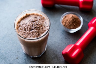 Chocolate Protein Shake Smoothie With Whey Protein Powder And Red Dumbbells. Sports Drink