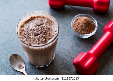 Chocolate Protein Shake Smoothie With Whey Protein Powder And Red Dumbbells. Sports Drink