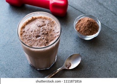 Chocolate Protein Shake Smoothie With Whey Protein Powder And Red Dumbbells. Sports Drink