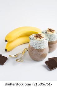 Chocolate pudding with chia seed and banana in the glass jars on the white background. Location vertical.