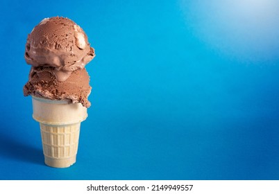 A Chocolate Rocky Road Ice Cream Cone on a Blue Background - Shutterstock ID 2149949557