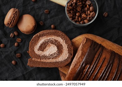 Chocolate roll with chocolate cream next to chocolate macaroons on a wooden board next to coffee beans on a dark background - Powered by Shutterstock