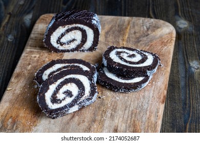 Chocolate Roll With A Creamy Curd Layer In Coconut Chips, A Roll Of Cakes And Cottage Cheese Cut Into Pieces