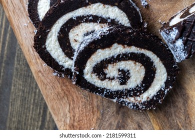 Chocolate Roll With A Creamy Curd Layer In Coconut Chips, A Roll Of Cakes And Cottage Cheese Cut Into Pieces