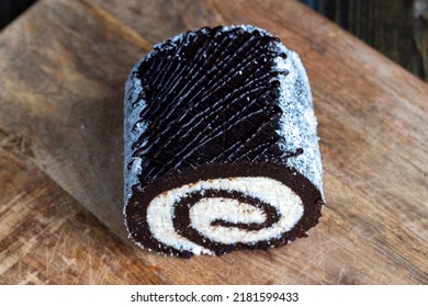 Chocolate Roll With A Creamy Curd Layer In Coconut Chips, A Roll Of Cakes And Cottage Cheese Cut Into Pieces