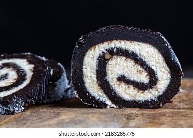 Chocolate Roll With A Creamy Curd Layer In Coconut Chips, A Roll Of Cakes And Cottage Cheese Cut Into Pieces