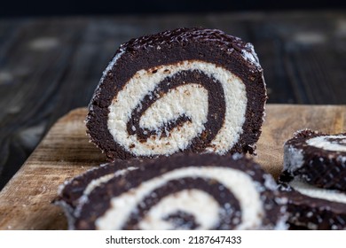 Chocolate Roll With A Creamy Curd Layer In Coconut Chips, A Roll Of Cakes And Cottage Cheese Cut Into Pieces