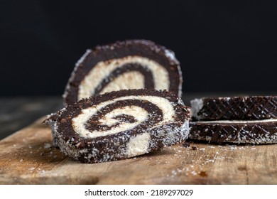 Chocolate Roll With A Creamy Curd Layer In Coconut Chips, A Roll Of Cakes And Cottage Cheese Cut Into Pieces