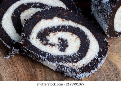 Chocolate Roll With A Creamy Curd Layer In Coconut Chips, A Roll Of Cakes And Cottage Cheese Cut Into Pieces