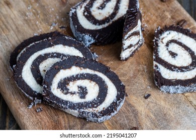 Chocolate Roll With A Creamy Curd Layer In Coconut Chips, A Roll Of Cakes And Cottage Cheese Cut Into Pieces