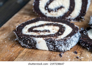 Chocolate Roll With A Creamy Curd Layer In Coconut Chips, A Roll Of Cakes And Cottage Cheese Cut Into Pieces