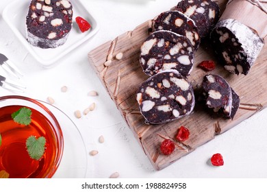 Chocolate sausage made of cookies, cocoa powder, nuts and dried berries with sugar powder. Dessert of Russian, Italian and Portuguese cuisines - Powered by Shutterstock