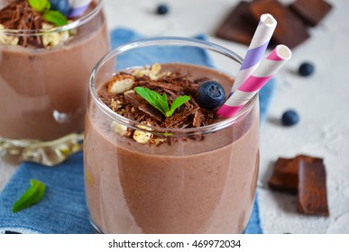 chocolate smoothie with banana, blueberries and almonds on a concrete background
